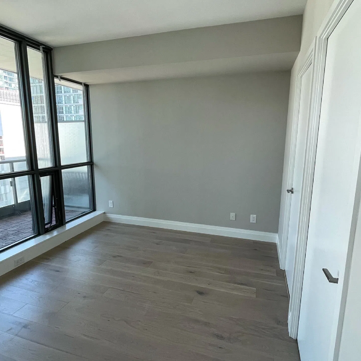A painter rolling a flat ceiling coat while painting a condo ceiling in Toronto with an extension pole and quality roller